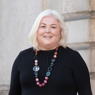 woman with colourful necklace smiling