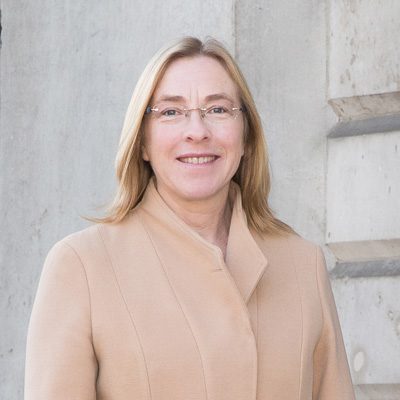 woman in beige coat smiling