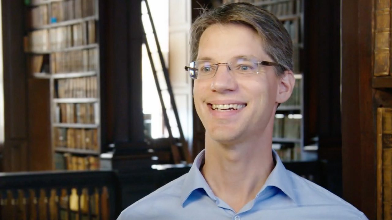 man with glasses speaking in library