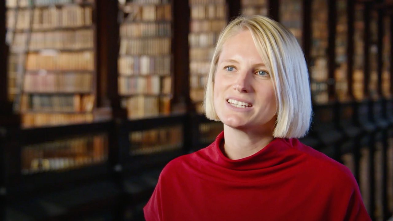 woman with red jumper in trinity long room