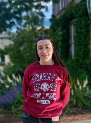 A woman wearing a red Trinity College sweater