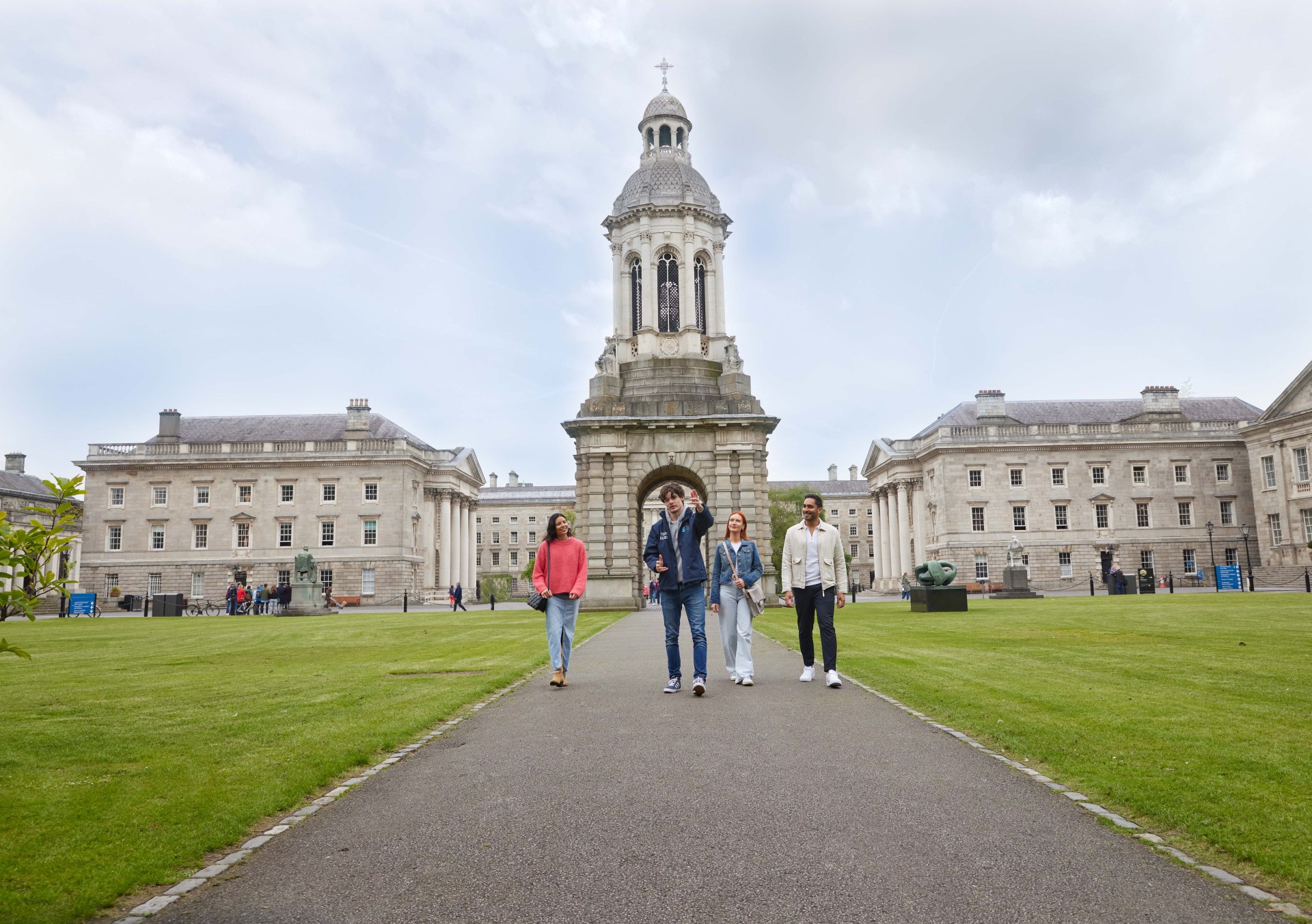 A Trinity guide with three tourists walking through Front Square during the historical walking tour of Trinity College.