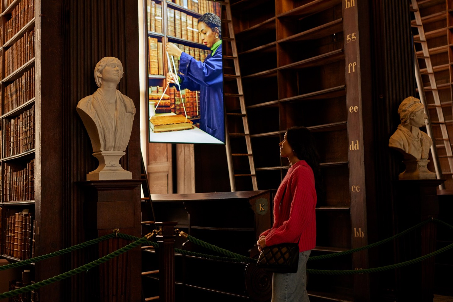 A woman looks at a decant screen in the Long Room