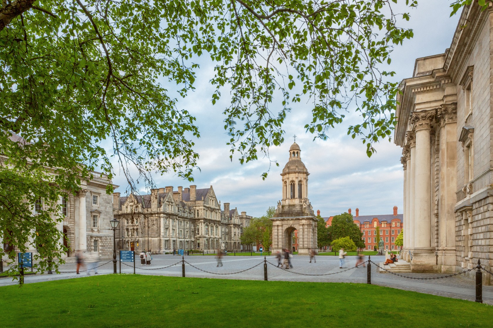 Trinity's Front Square with grass, trees and the bell tower.
