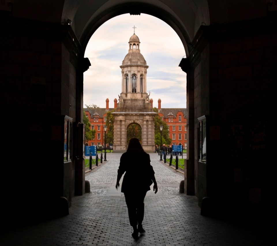 A lone figure walking through the front arch in Trinity into Front Square with the bell tower ahead