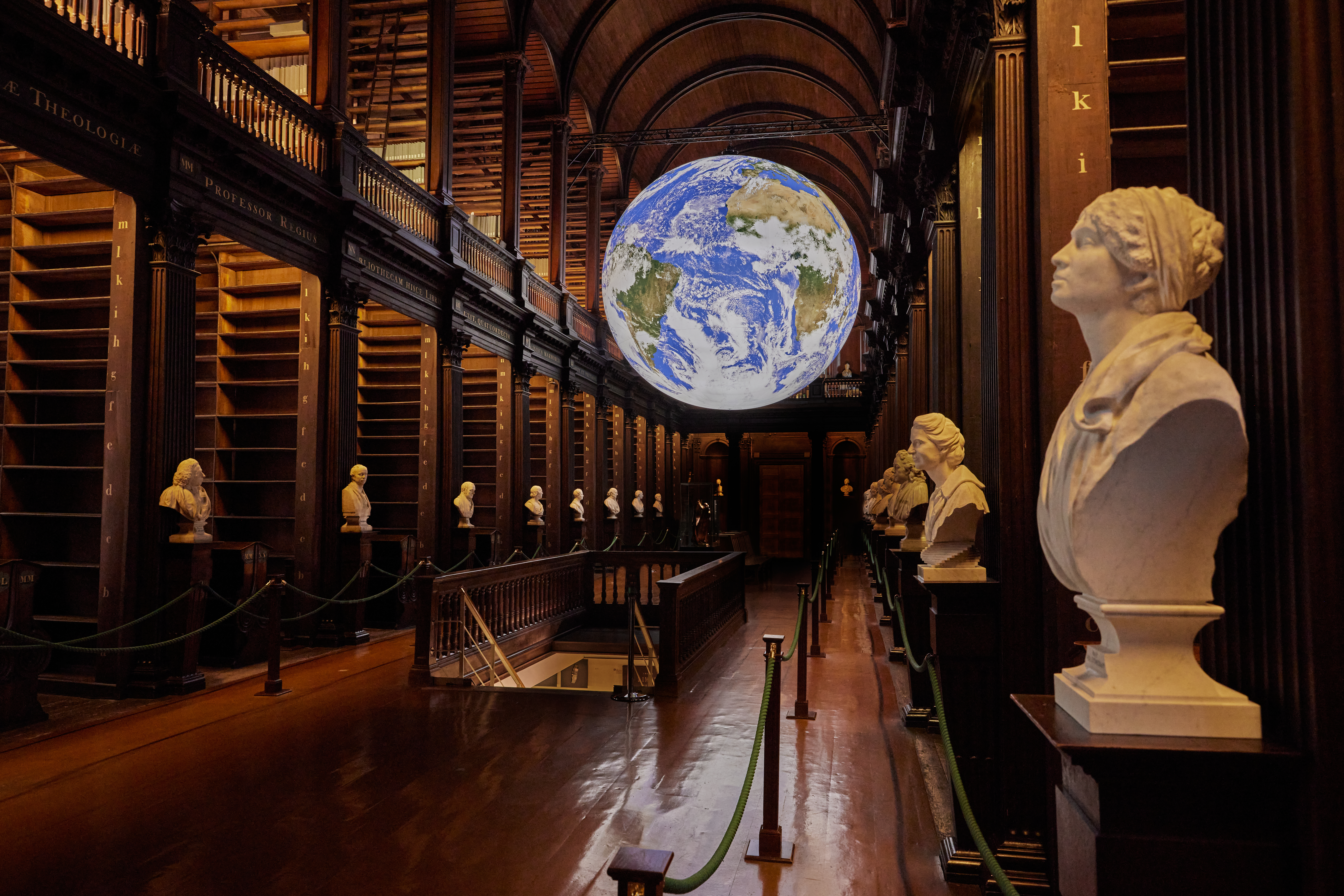 Image of the Gaia display in the Long Room, with white sculptures along the aisles of bookshelves