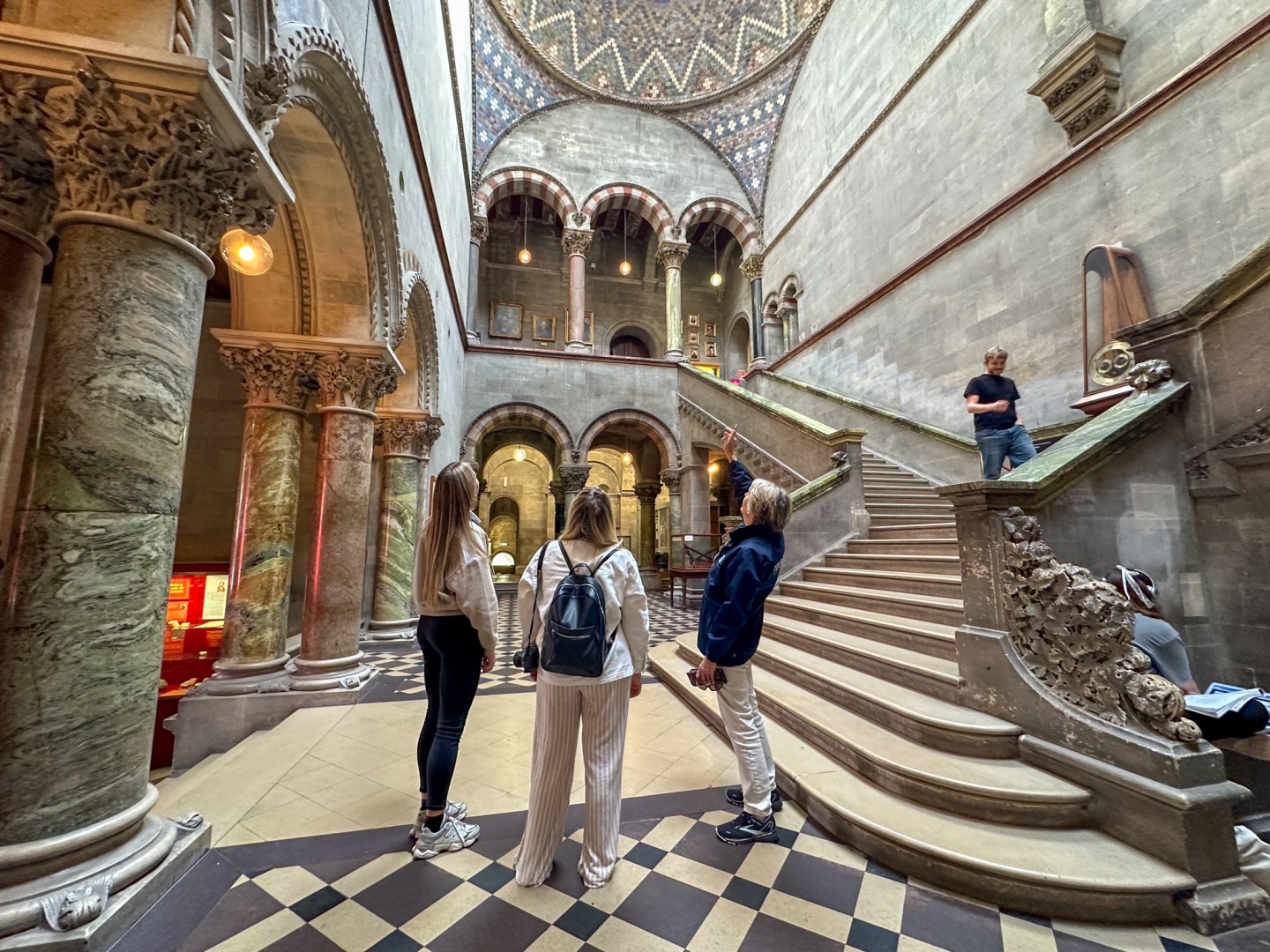 Three people looking up at the ceiling of the Museum Building