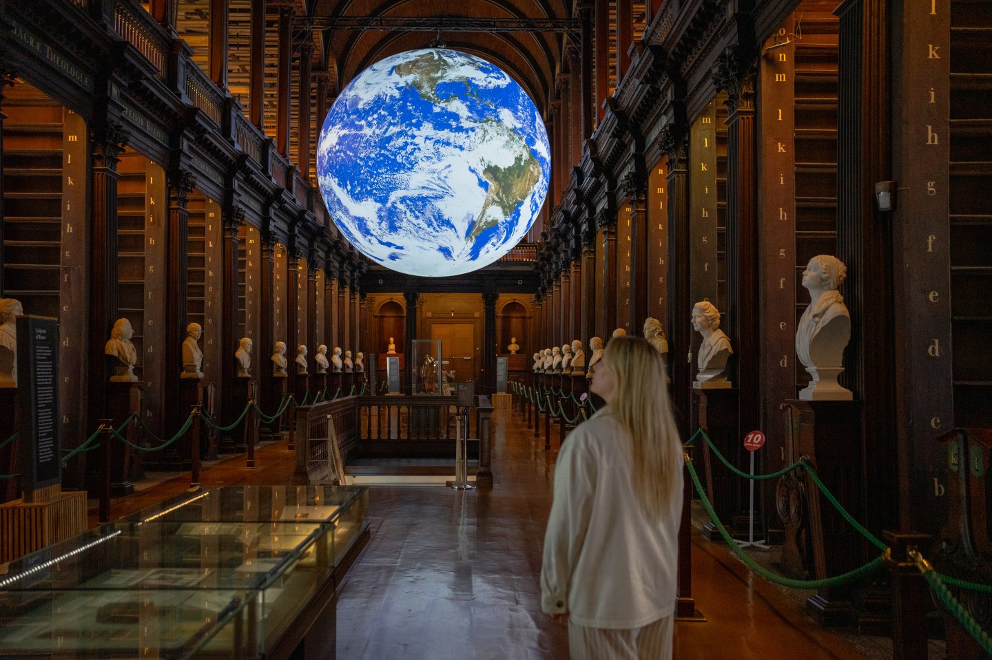 Image of a woman looking around at the displays in the Long Room