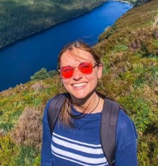 Image of Evelina wearing red-lensed glasses and a blue and white striped sweater