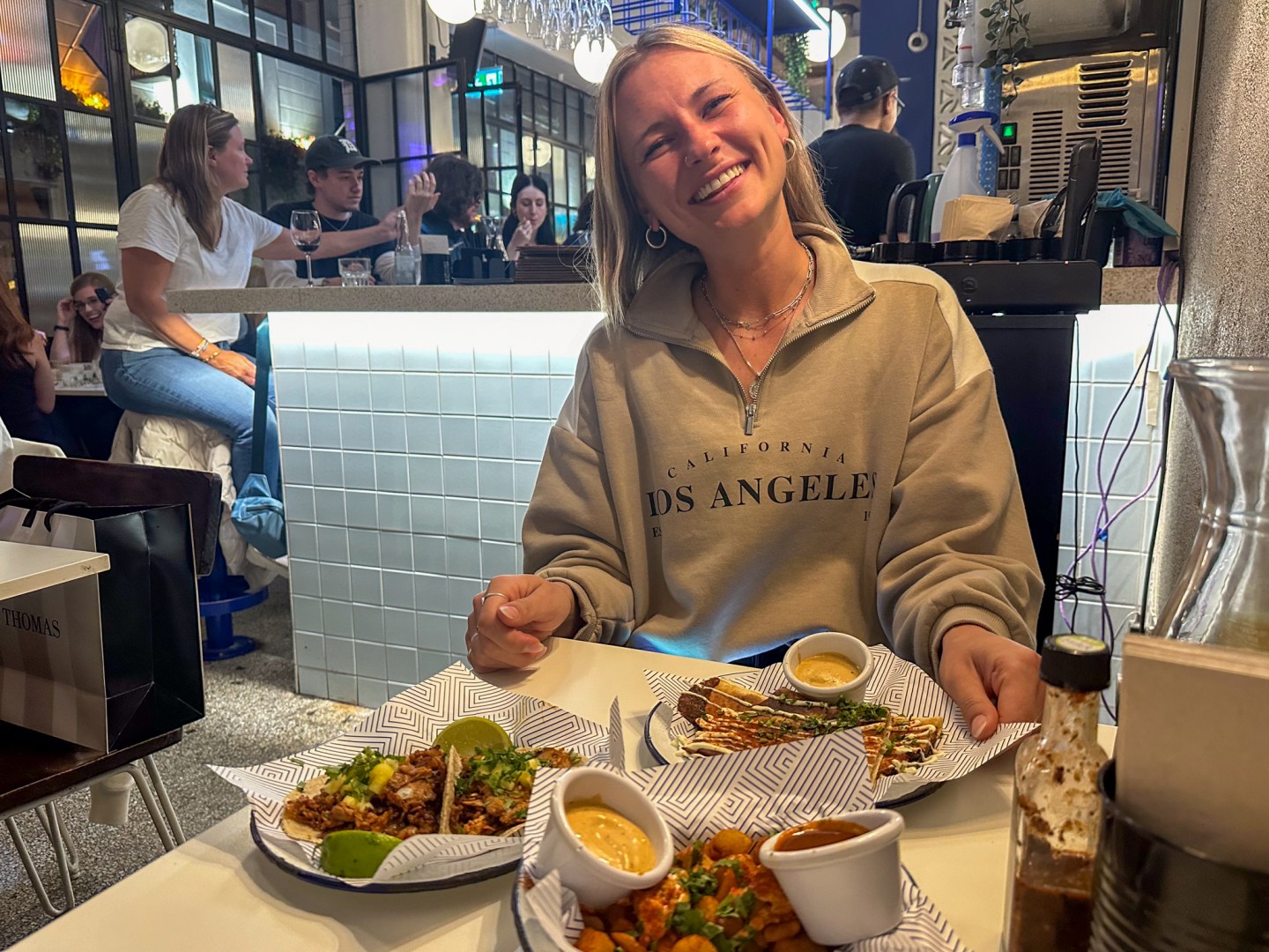 A woman smiling as she begins to eat her meal at Mexican restaurant Masa in Dublin