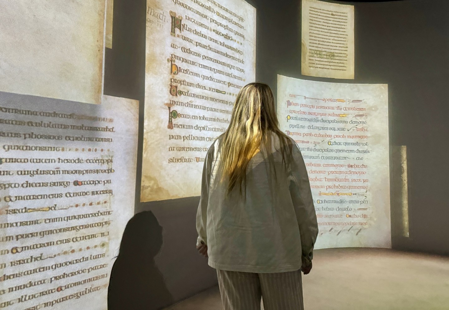 A women admires the pages displayed from The Book of Kells
