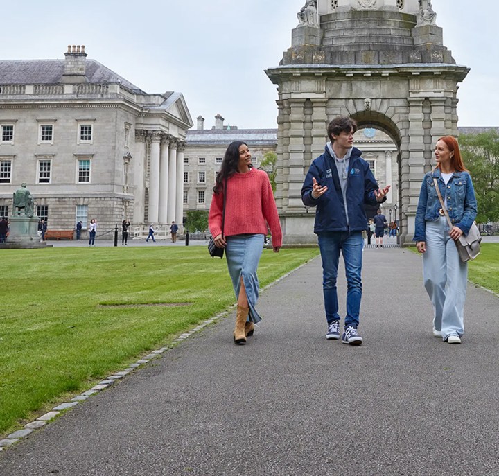 A Trinity guide with two tourists walking through Front Square during the historical walking tour of Trinity College.