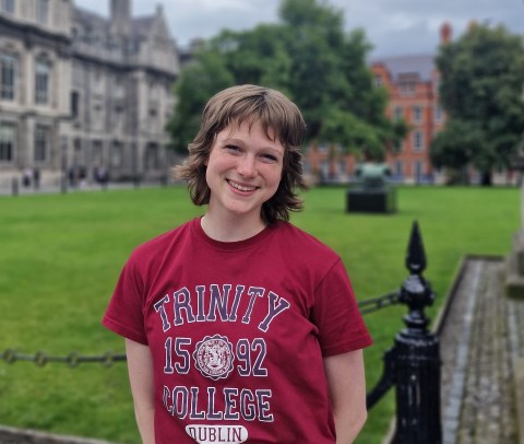 Photo of Katie on Trinity campus, wearing a red Trinity College t-shirt