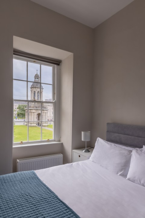 A bedroom featuring a window with a view of Trinity Front Square in the accommodation at Trinity College Dublin.