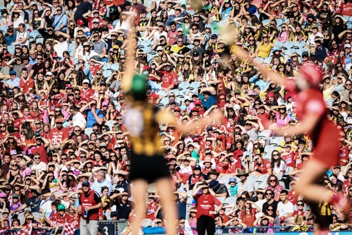 Image of the crowd watching two players battle for the sliotar during the All-Ireland Camogie Final on 7th August 2022