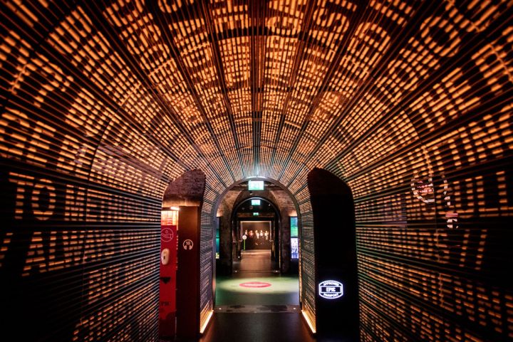 A tunnel with orange text, leading into another room